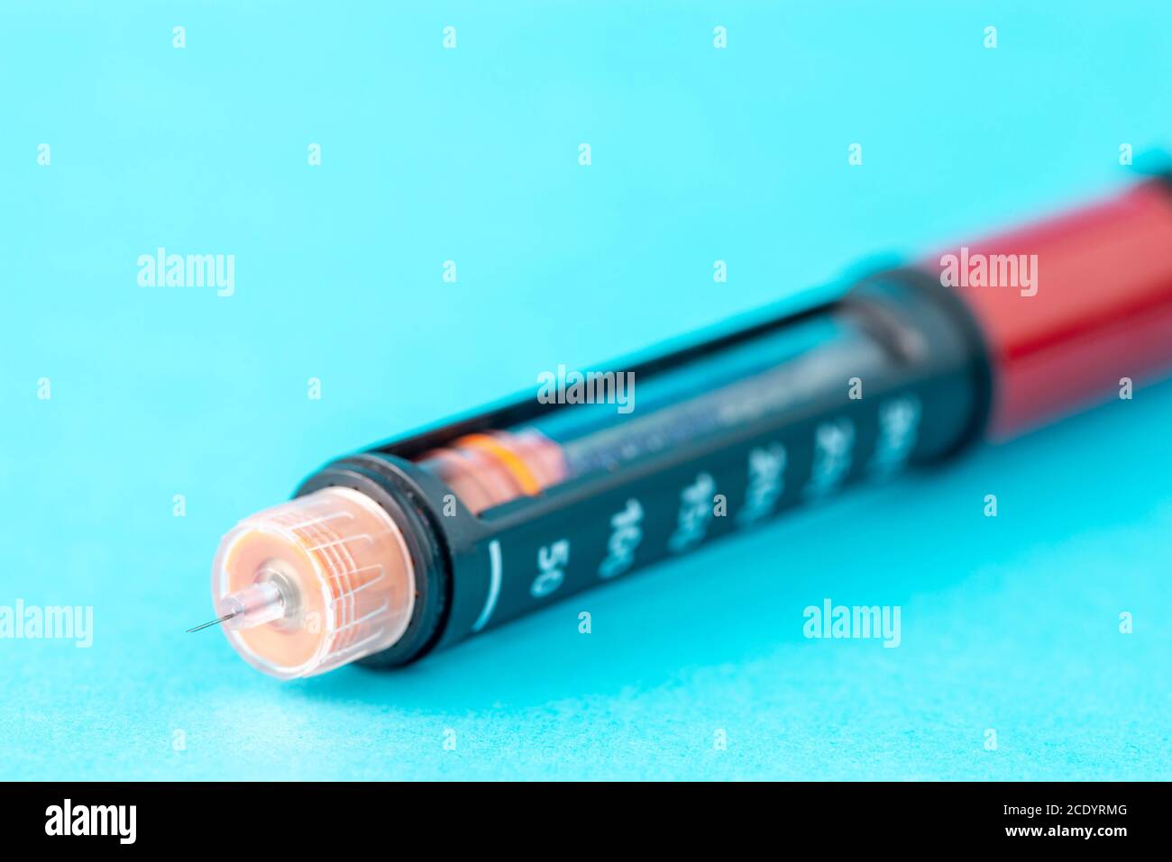 Gros plan de l'aiguille du stylo à insuline sur fond bleu. Banque D'Images