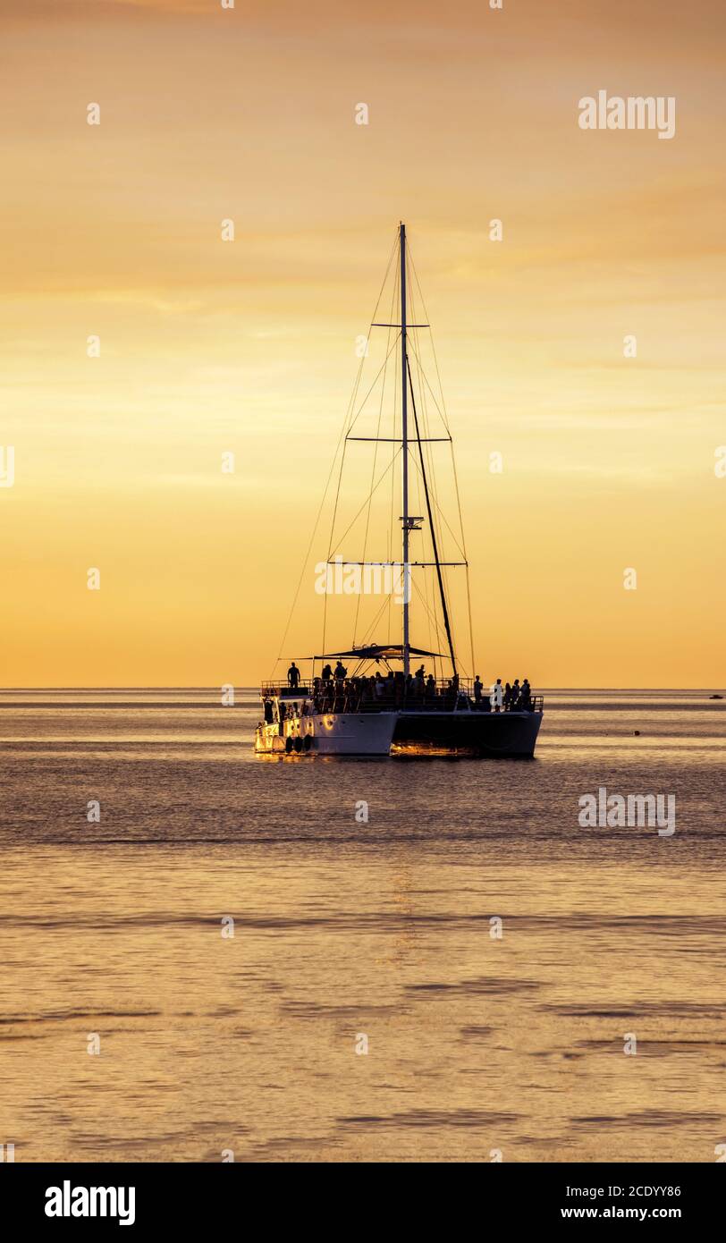 Australie occidentale – Silhouette des personnes célébrant sur un catamaran au coucher du soleil, lumière du soir sur la mer Banque D'Images