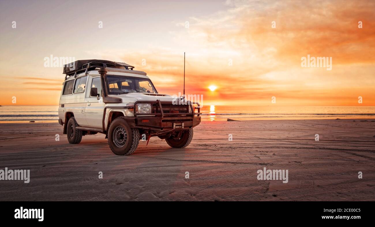 Australie occidentale – aventure dans l'Outback avec 4x4 au plage d'un océan au lever du soleil et un ciel rouge Banque D'Images