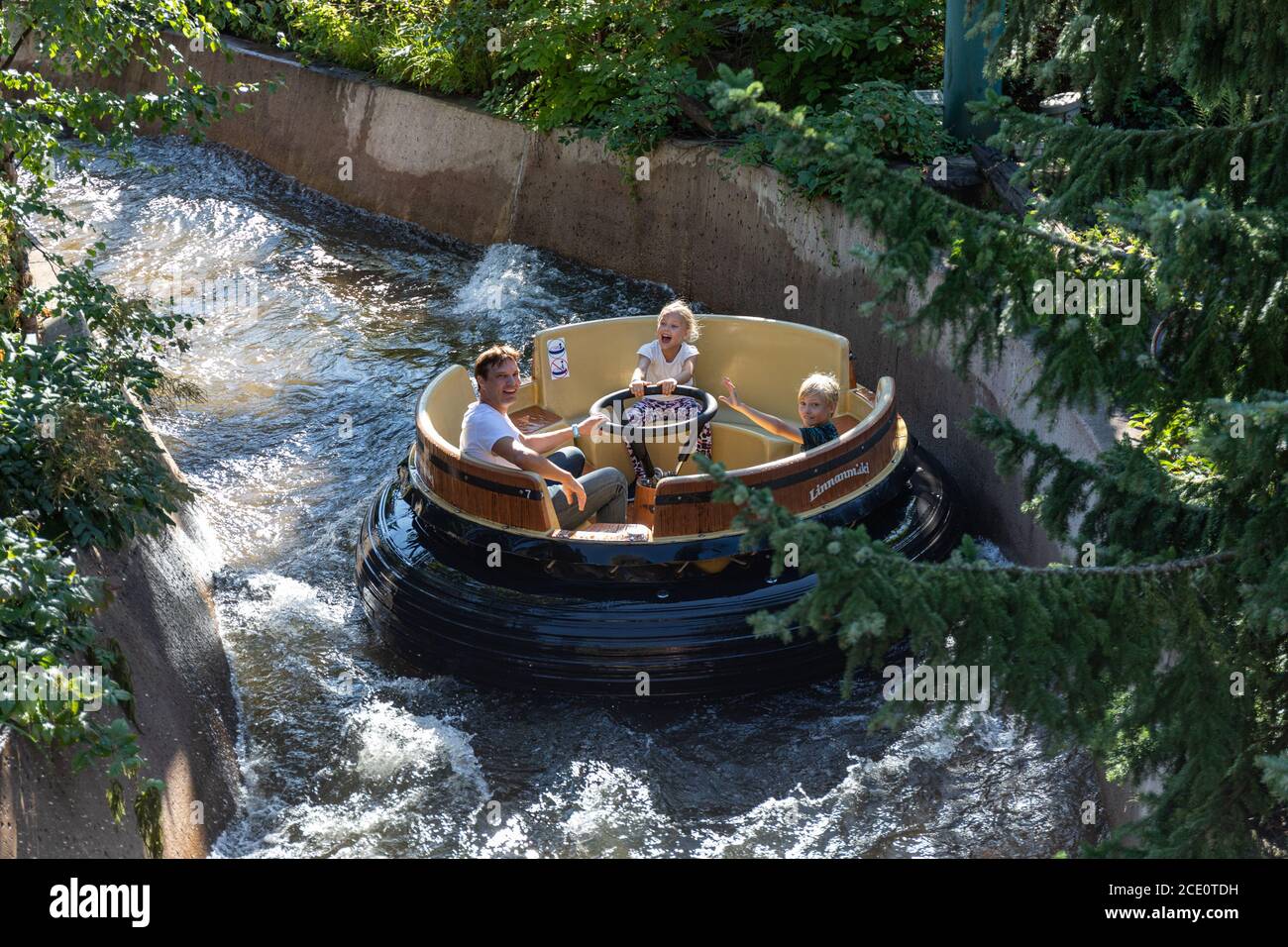 Un homme et deux enfants aux rapides de la rivière Hurjakuru se trouvent dans le parc d'attractions de Linnanmäki à Helsinki, en Finlande Banque D'Images