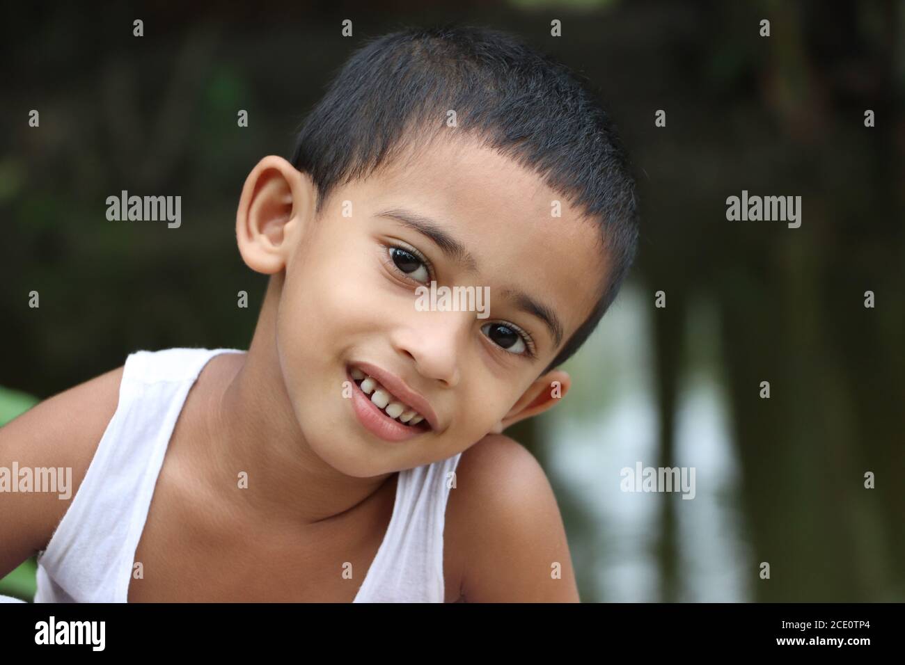 Mignon petit enfant asiatique gai regardant l'appareil photo, gros plan, yeux oreille nez bouche Banque D'Images