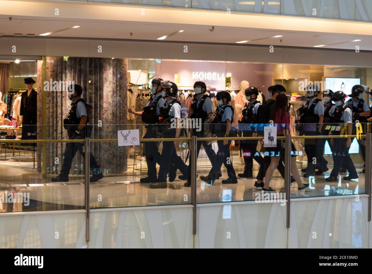 Hong Kong, Chine. 30 août 2020. La police anti-émeute marche dans le centre commercial Moko avant que des affiches apposées par les manifestants sur des barrières de verre faisant référence à l'idiome chinois « appeler un cerf à cheval » (qui est devenu populaire après que Lam Cheuk-Ting et Ted hui ont été arrêtés pour avoir « pris des émeutes » lors des incidents de Yuen long en juillet 2019). Crédit : Marc R. Fernandes/Alamy Live News Banque D'Images