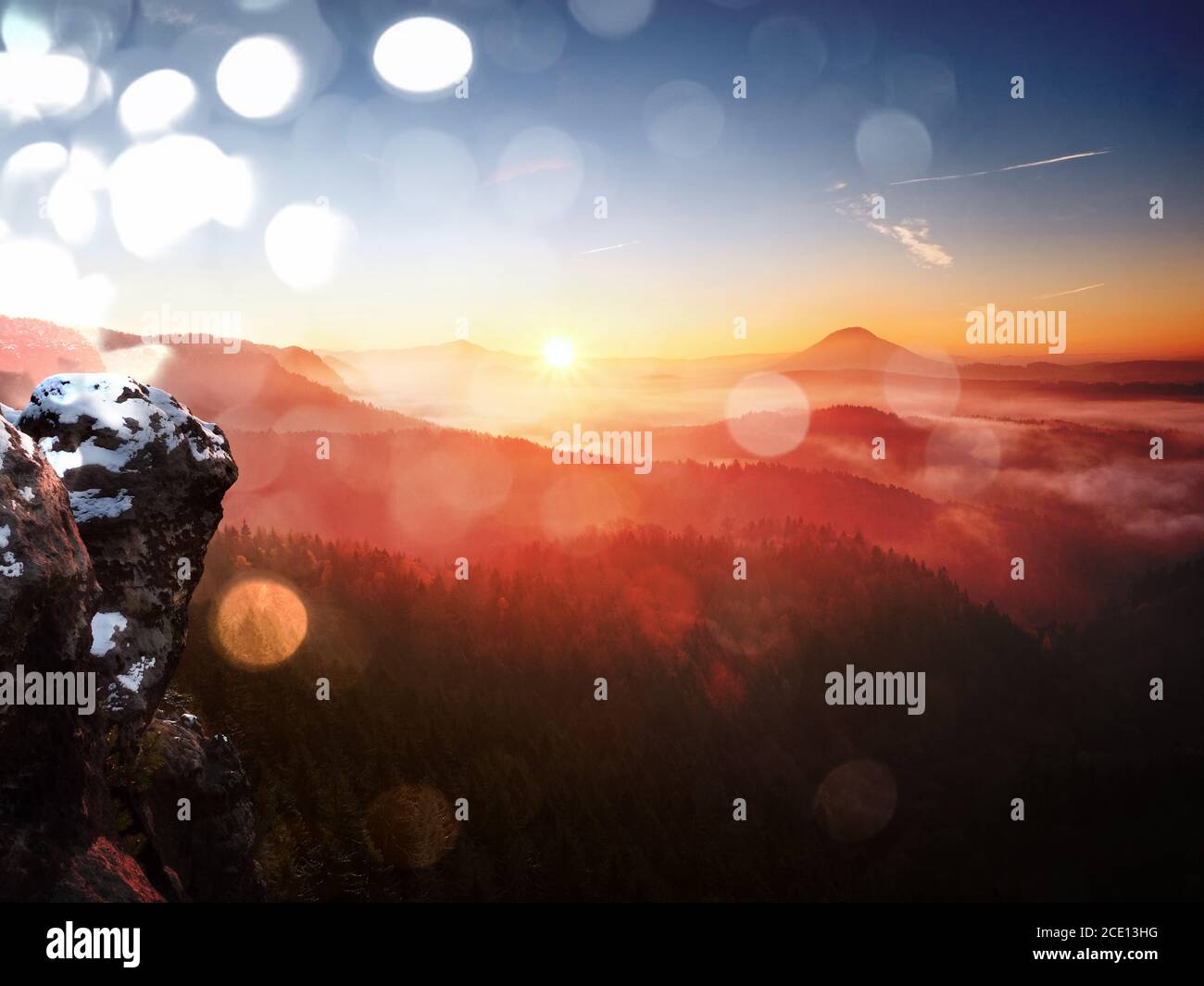 Effet de film. Première couverture de neige en poudre sur les rochers de grès au-dessus du parc de la vallée. Brouillard épais dans la vallée point de vue sous-tendre. Automne frais Banque D'Images