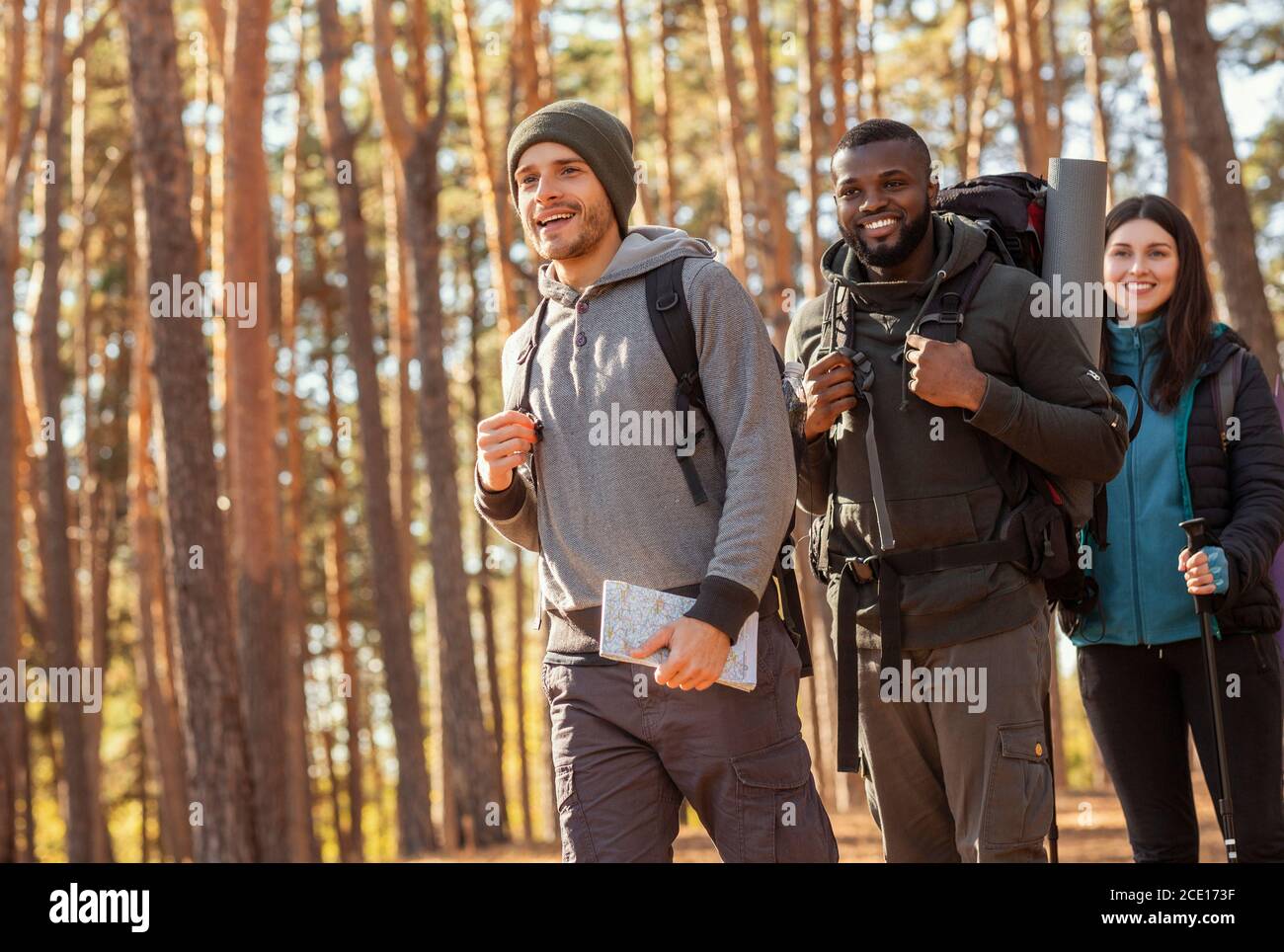 Trois amis multiraciaux joyeux randonnée en forêt Banque D'Images