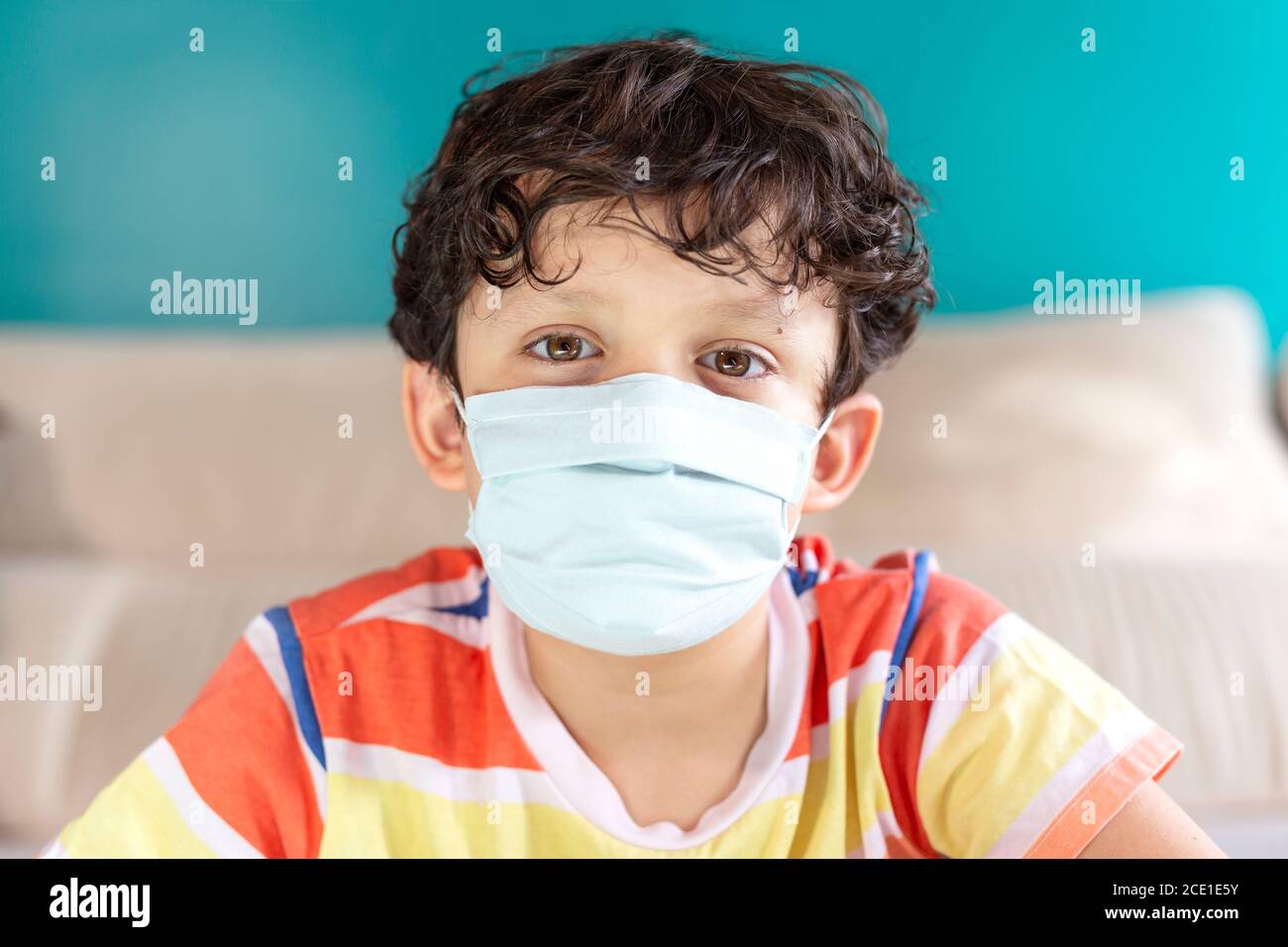 Portrait d'un petit garçon à la maison portant un masque facial. Concepts de protection contre les virus et de contrôle des infections. Banque D'Images