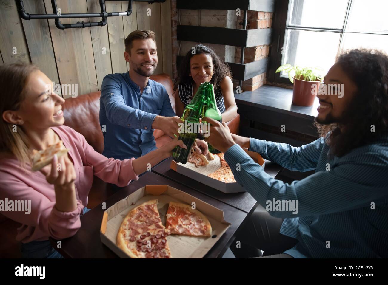 Gros plan surjoyaient diverses personnes qui se trinquèrent avec des bouteilles de bière Banque D'Images