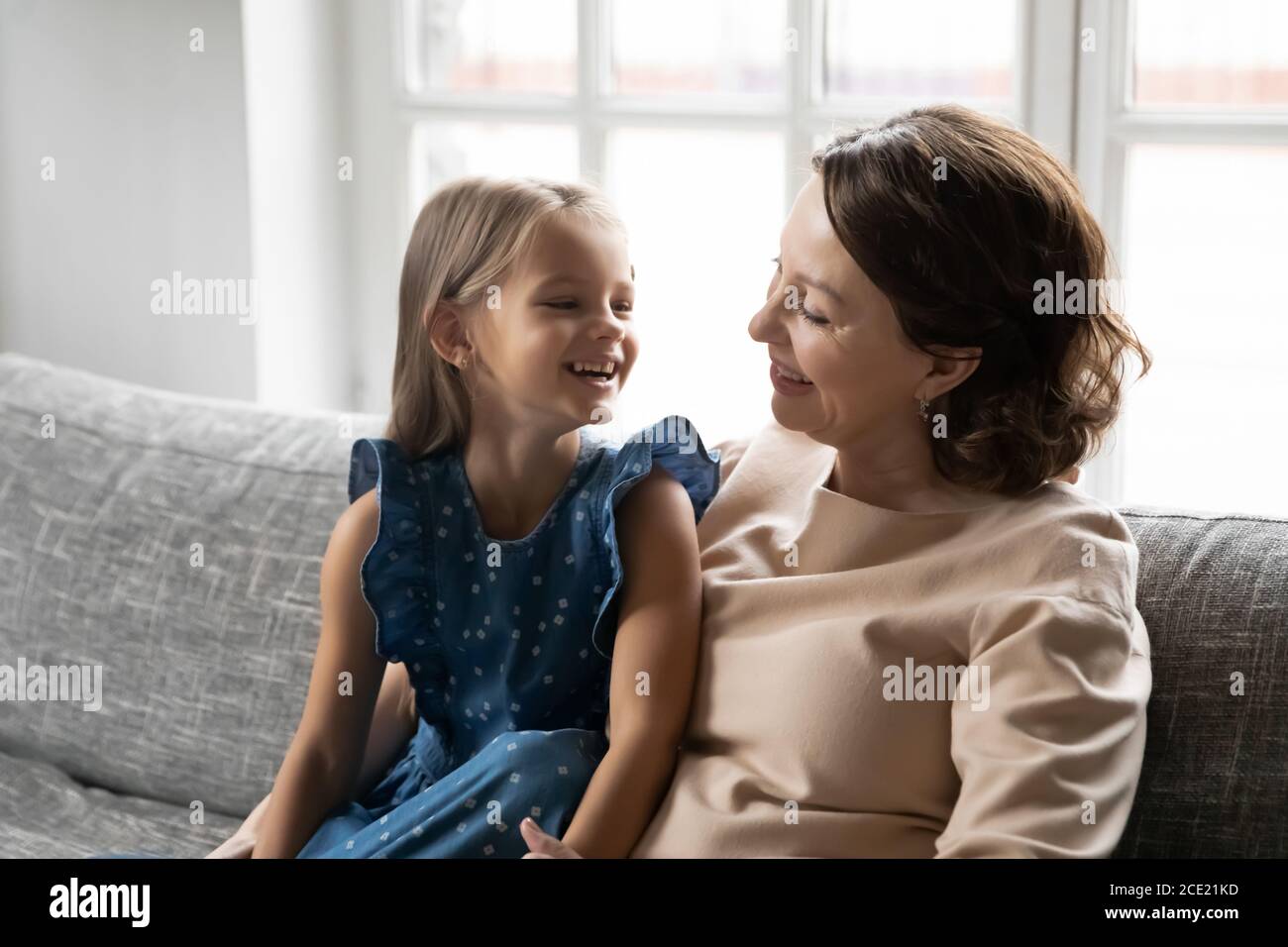 Bonne petite fille d'enfant appréciant la conversation drôle avec granny. Banque D'Images