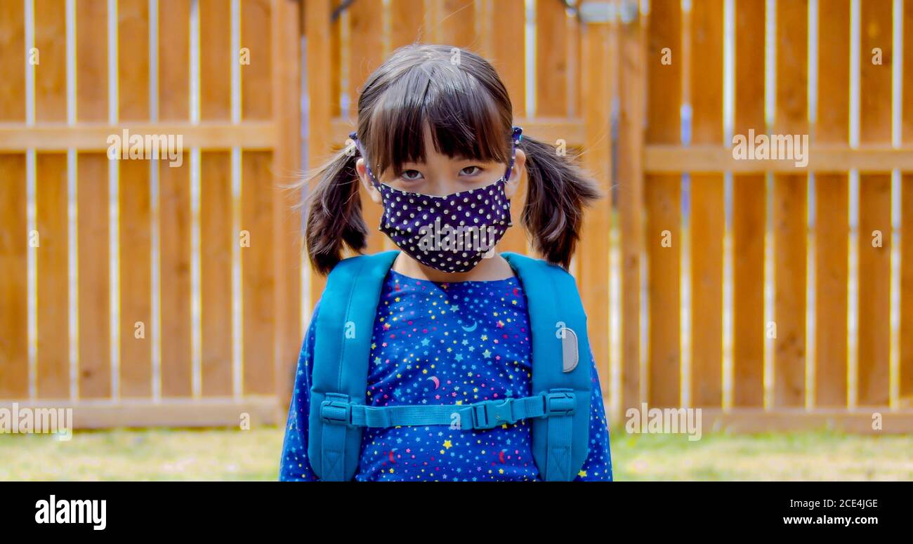 Un étudiant de jardin plus kidder portant un masque de visage prêt à retourner à l'école. Banque D'Images