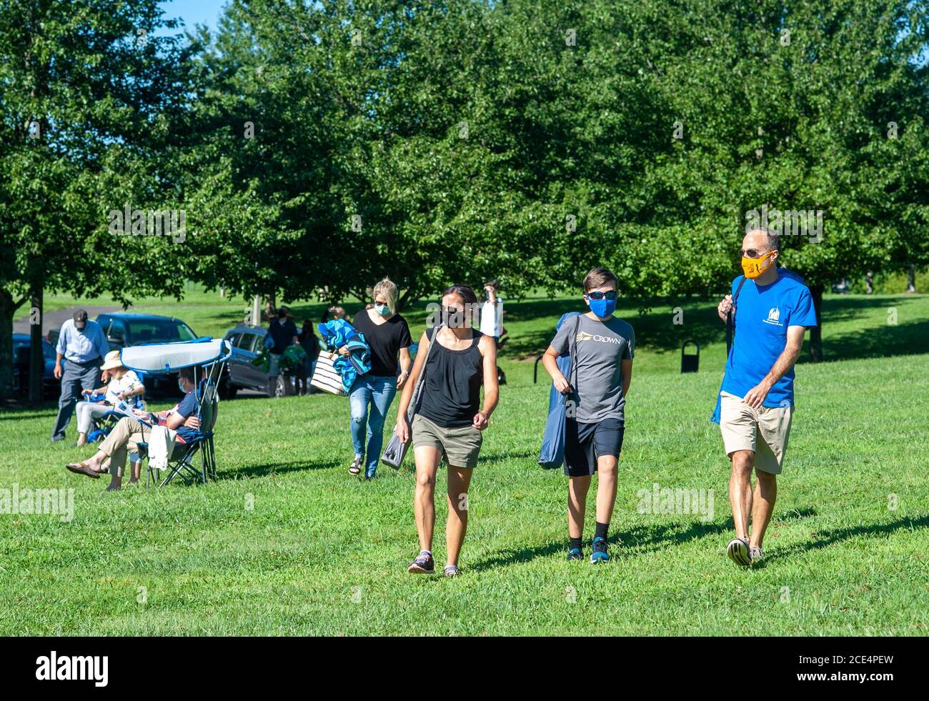 Doylestown, États-Unis. 30 août 2020. De gauche à droite, Krista Spadt, Evan Spadt et Steve Spadt de Warrington arrivent avec des chaises pour un service d'église en plein air tenu par l'église presbytérienne de Doylestown le dimanche 30 août 2020 à Central Park à Doylestown, Pennsylvanie. C'est la première fois depuis mars que la congrégation peut adorer au même endroit en raison des restrictions de la COVID-19. Des masques étaient nécessaires pour prendre des distances sociales afin de maintenir des protocoles de santé et de sécurité. Crédit : William Thomas Cain/Alay Live News Banque D'Images