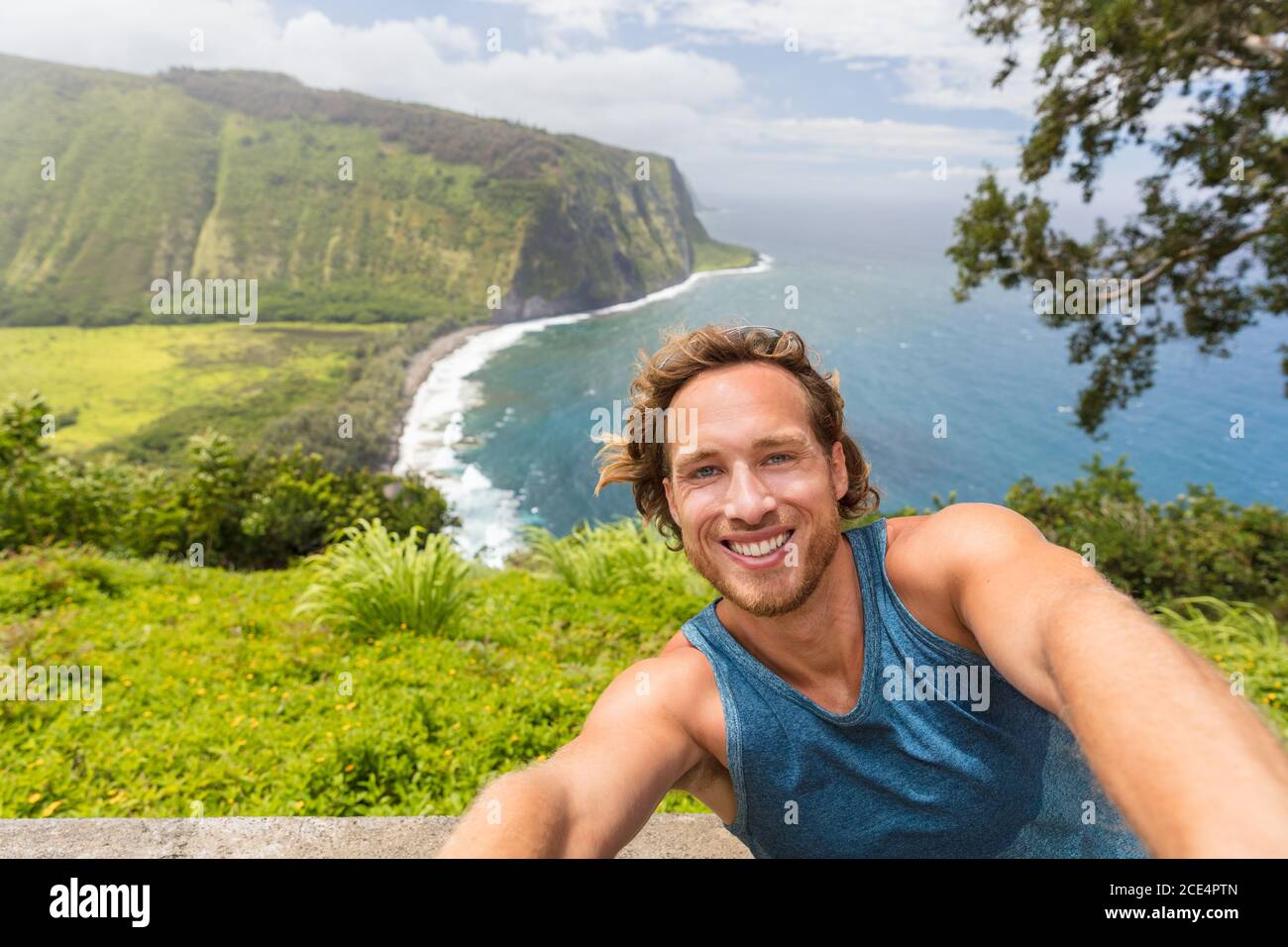 Selfie touriste randonneur prenant une photo d'auto-portrait au point de vue de Waipio Valley à Big Island, Hawaï. Un routard homme souriant au téléphone de l'appareil photo Banque D'Images
