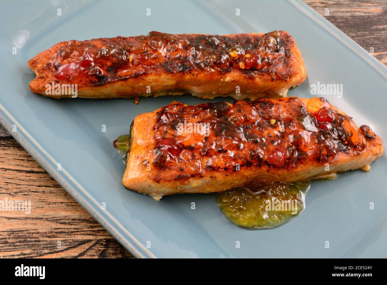 Filets de saumon grillé et sauce au poivre rouge assiette de service bleue Banque D'Images