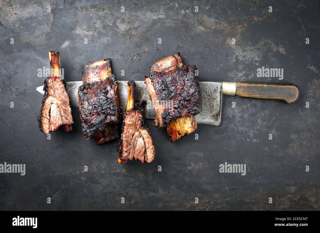 Griller les côtes de bœuf de mandrin avec du frottement chaud comme dessus vue sur un couteau sur une planche rustique Banque D'Images