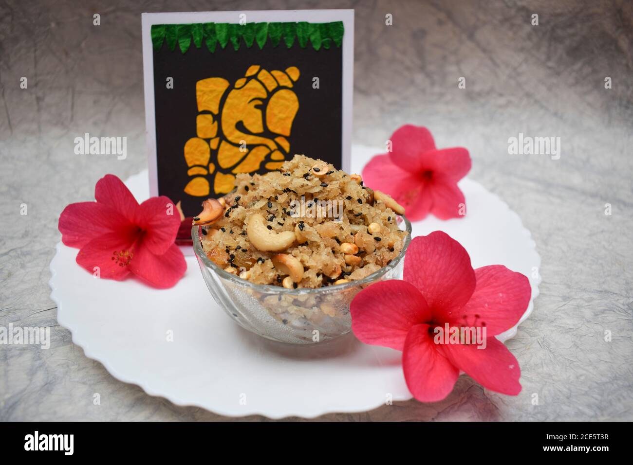 Happy Ganesh chaturthi spécial prasadam Sweet dish festival item Panchakajjjaya offert à Ganapati avec des fleurs d'hibiscus rouges sur fond blanc. INDI Banque D'Images