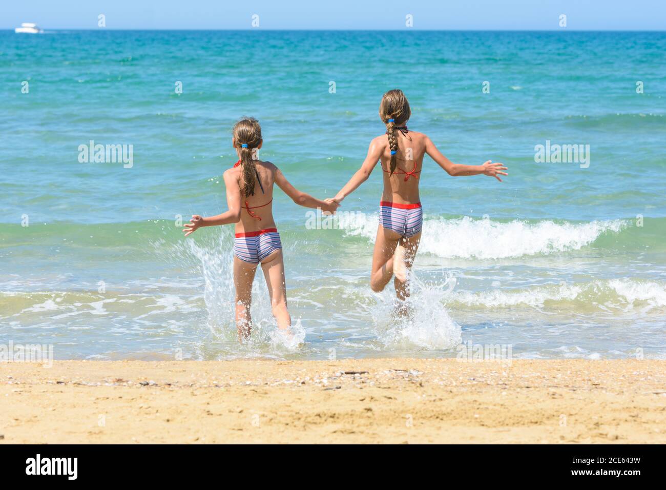 Les enfants qui tiennent les mains nagent dans la mer Banque D'Images