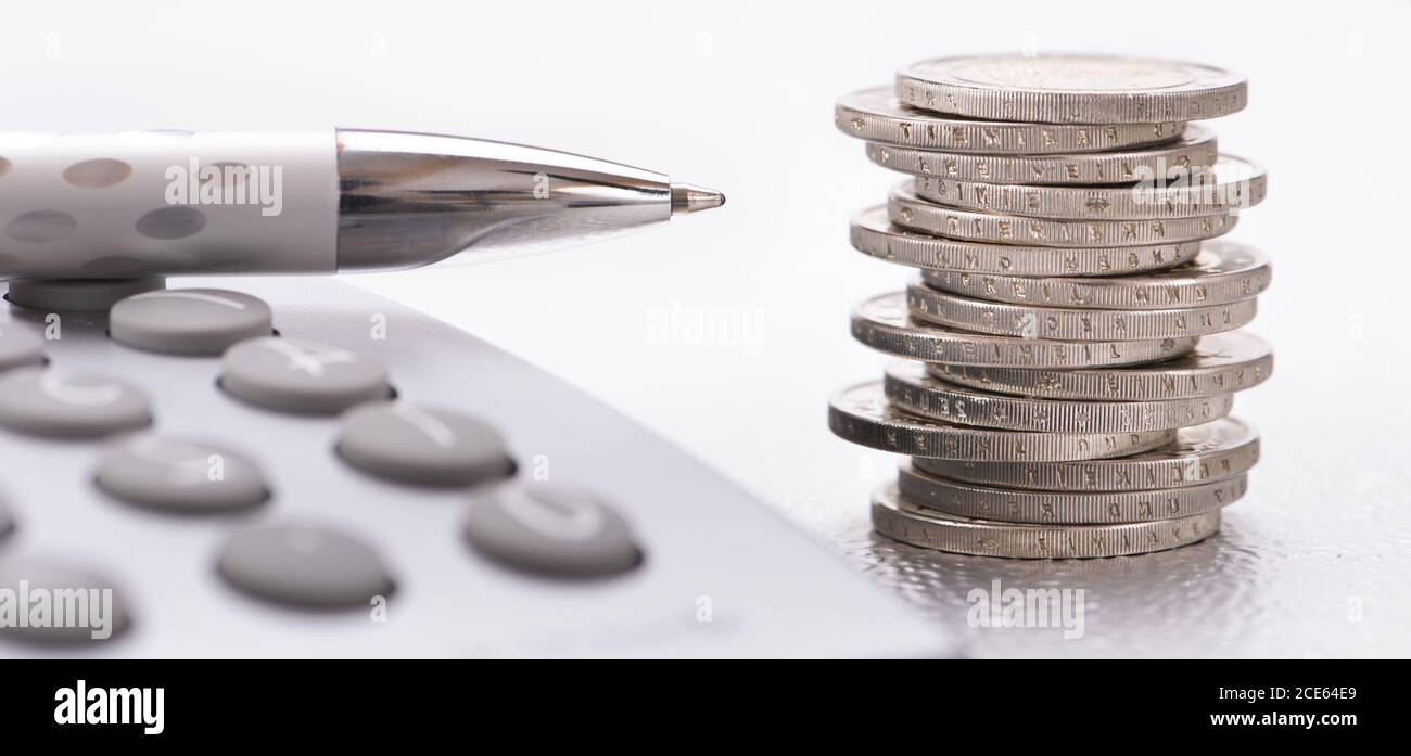 Pièces en euros empilées et calculatrice Banque D'Images