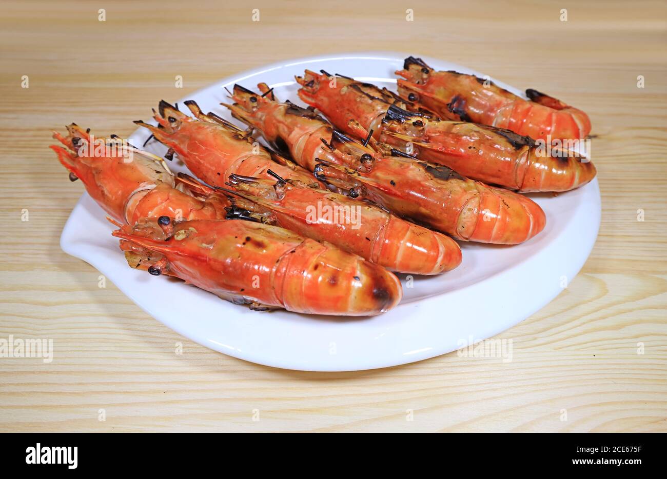 Assiette de crevettes grillées à la rivière servie sur une table en bois Banque D'Images