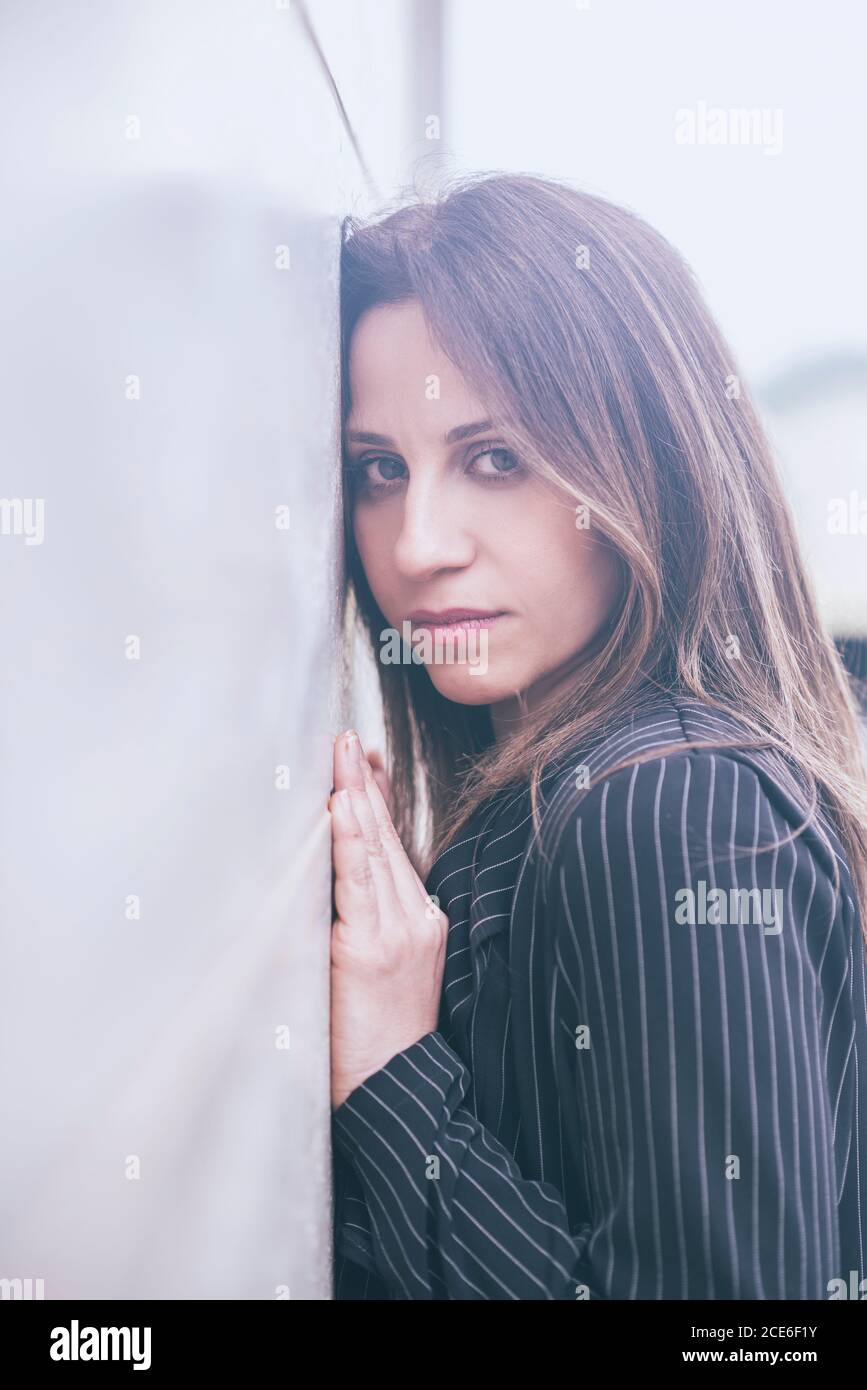 Belle femme penchée contre le mur Banque D'Images