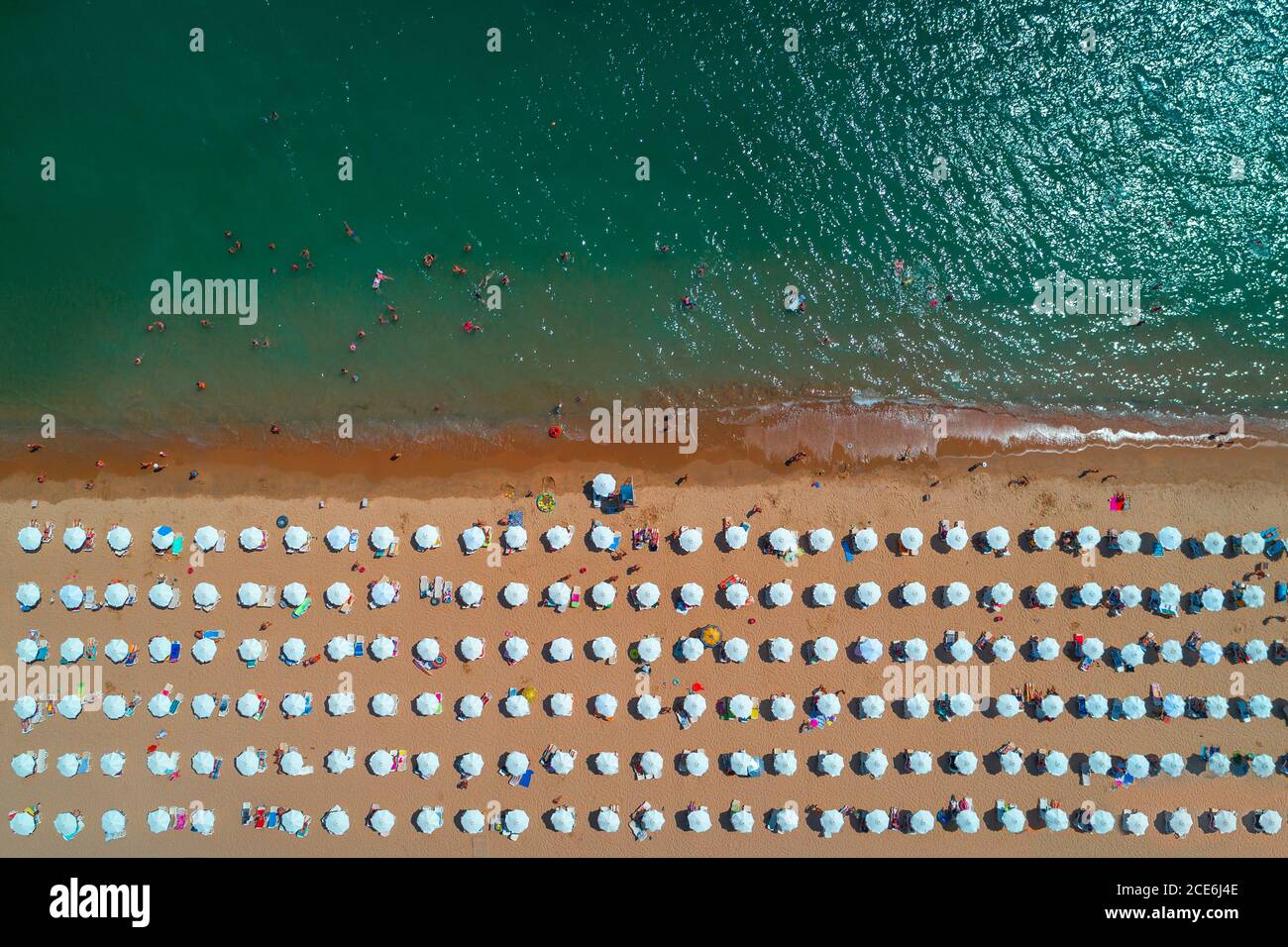 Vue de dessus de l'antenne sur la plage. Parapluies, le sable et les vagues de la mer Banque D'Images