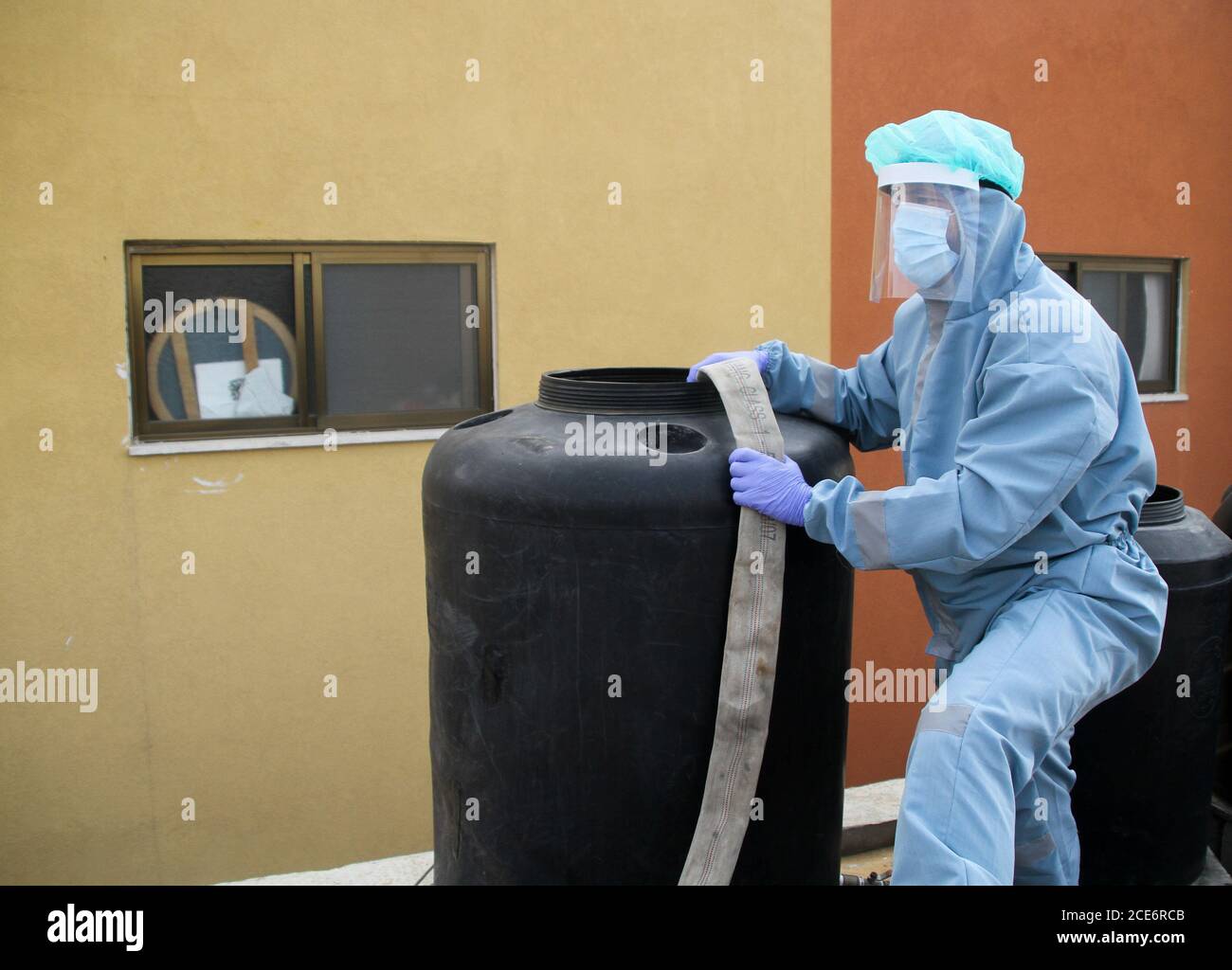 30 août 2020 : Gaza, Palestine. 30 août 2020. Les équipes palestiniennes de défense civile livrent de l'eau potable aux foyers des résidents du camp de réfugiés de Jabalia infectés par le coronavirus, car ils restent en quarantaine et ne peuvent pas récupérer de l'eau potable. Depuis que les premiers cas de coronavirus ont été détectés dans la communauté de Gaza au début de la semaine dernière, le nombre de personnes infectées a régulièrement augmenté à plus de 180 dans l'enclave palestinienne assiégée et densément peuplée. La crise aigue de l'eau dans la bande, où plus de 95 pour cent de l'eau douce ne convient pas à la consommation humaine, met en évidence le déjà grave Banque D'Images