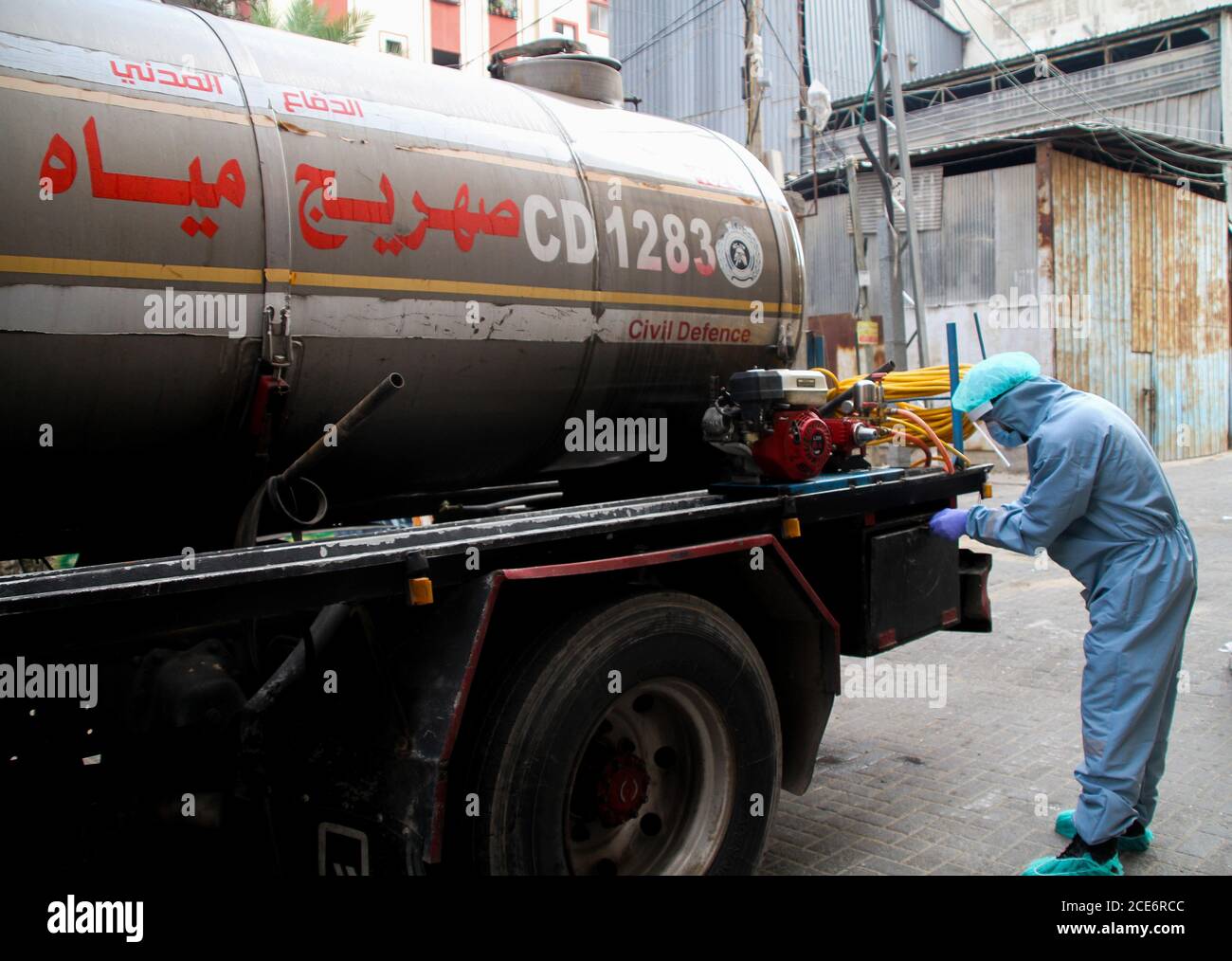 30 août 2020 : Gaza, Palestine. 30 août 2020. Les équipes palestiniennes de défense civile livrent de l'eau potable aux foyers des résidents du camp de réfugiés de Jabalia infectés par le coronavirus, car ils restent en quarantaine et ne peuvent pas récupérer de l'eau potable. Depuis que les premiers cas de coronavirus ont été détectés dans la communauté de Gaza au début de la semaine dernière, le nombre de personnes infectées a régulièrement augmenté à plus de 180 dans l'enclave palestinienne assiégée et densément peuplée. La crise aigue de l'eau dans la bande, où plus de 95 pour cent de l'eau douce ne convient pas à la consommation humaine, met en évidence le déjà grave Banque D'Images