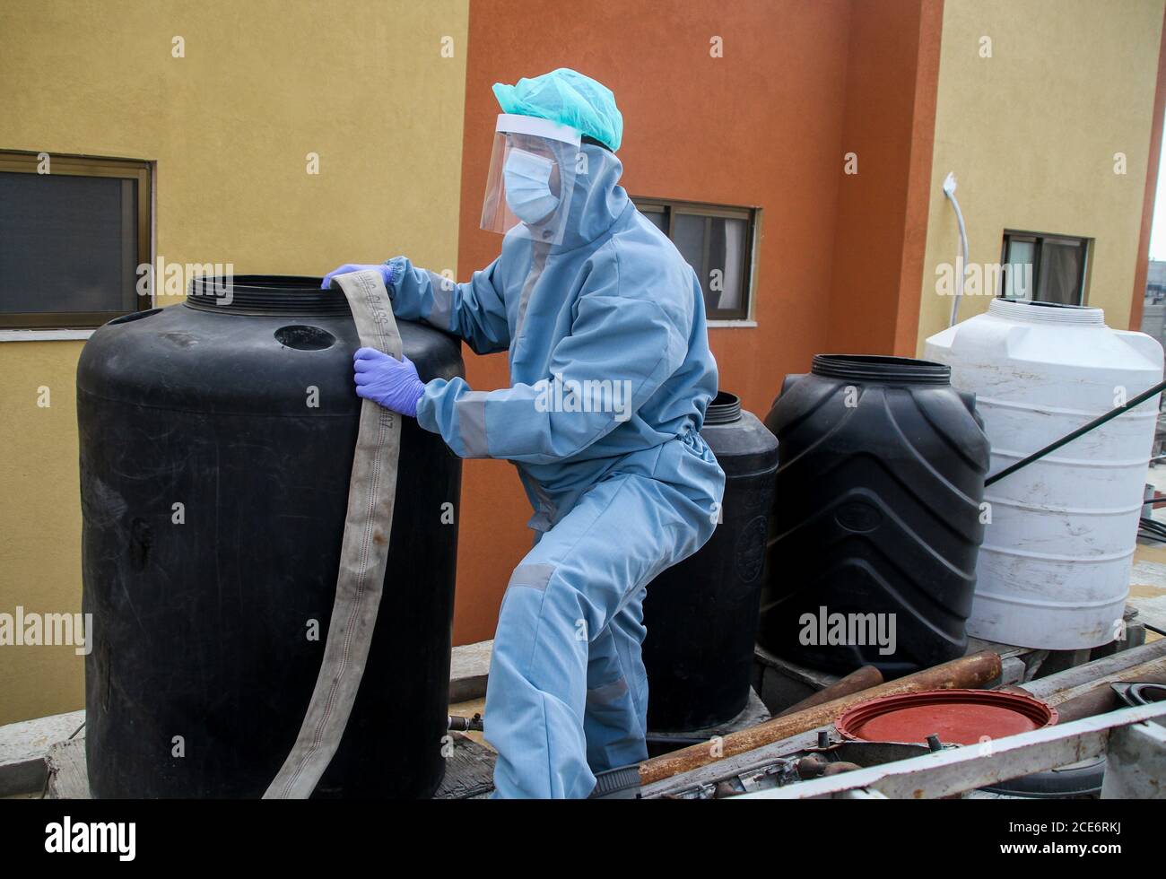 30 août 2020 : Gaza, Palestine. 30 août 2020. Les équipes palestiniennes de défense civile livrent de l'eau potable aux foyers des résidents du camp de réfugiés de Jabalia infectés par le coronavirus, car ils restent en quarantaine et ne peuvent pas récupérer de l'eau potable. Depuis que les premiers cas de coronavirus ont été détectés dans la communauté de Gaza au début de la semaine dernière, le nombre de personnes infectées a régulièrement augmenté à plus de 180 dans l'enclave palestinienne assiégée et densément peuplée. La crise aigue de l'eau dans la bande, où plus de 95 pour cent de l'eau douce ne convient pas à la consommation humaine, met en évidence le déjà grave Banque D'Images