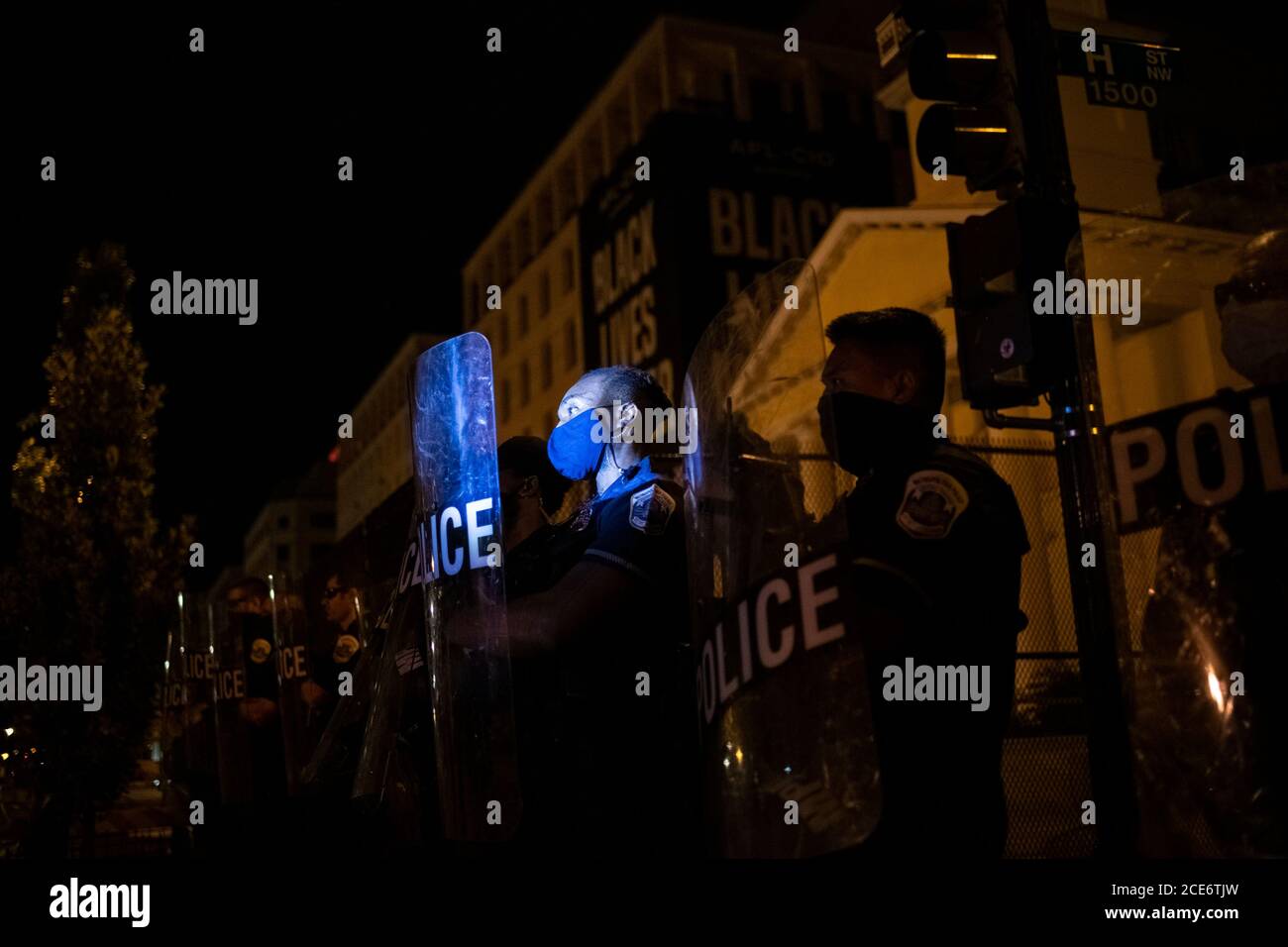 Washington, États-Unis. 31 août 2020. Les manifestants éclairent les policiers dans des engins anti-émeutes derrière une barrière, tandis que les manifestants qui avaient défilé pour la justice raciale sont retournés sur la Black Lives Matter Plaza à Washington, DC, le 30 août 2020, dans le contexte de la pandémie du coronavirus. La nuit après que la police ait violemment poussé les foules hors de Black Lives Matter Plaza, des manifestants non violents se sont de nouveau rassemblés là-bas avant de marcher, et à son retour sur la place pour rassembler la police dans des engins anti-émeutes les a agressivement poussés hors de la place, causant des blessures. (Graeme Sloan/Sipa USA) Credit: SIPA USA/Alay Live News Banque D'Images