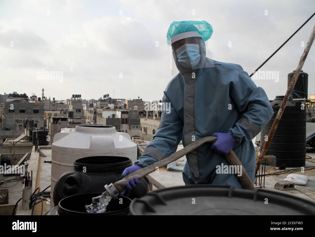 30 août 2020 : Gaza, Palestine. 30 août 2020. Les équipes palestiniennes de défense civile livrent de l'eau potable aux foyers des résidents du camp de réfugiés de Jabalia infectés par le coronavirus, car ils restent en quarantaine et ne peuvent pas récupérer de l'eau potable. Depuis que les premiers cas de coronavirus ont été détectés dans la communauté de Gaza au début de la semaine dernière, le nombre de personnes infectées a régulièrement augmenté à plus de 180 dans l'enclave palestinienne assiégée et densément peuplée. La crise aigue de l'eau dans la bande, où plus de 95 pour cent de l'eau douce ne convient pas à la consommation humaine, met en évidence le déjà grave Banque D'Images