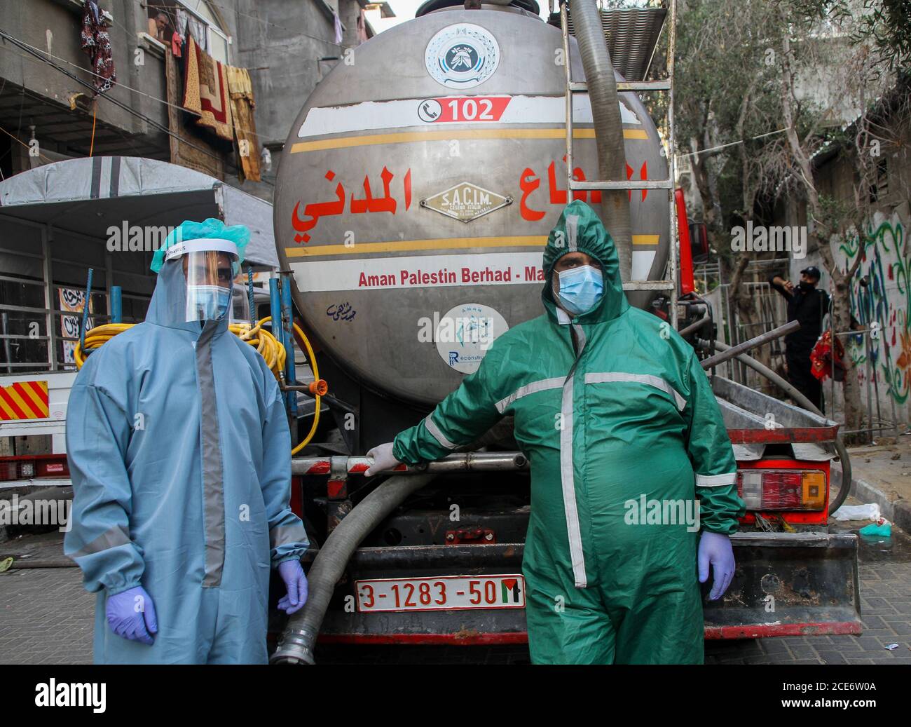 30 août 2020 : Gaza, Palestine. 30 août 2020. Les équipes palestiniennes de défense civile livrent de l'eau potable aux foyers des résidents du camp de réfugiés de Jabalia infectés par le coronavirus, car ils restent en quarantaine et ne peuvent pas récupérer de l'eau potable. Depuis que les premiers cas de coronavirus ont été détectés dans la communauté de Gaza au début de la semaine dernière, le nombre de personnes infectées a régulièrement augmenté à plus de 180 dans l'enclave palestinienne assiégée et densément peuplée. La crise aigue de l'eau dans la bande, où plus de 95 pour cent de l'eau douce ne convient pas à la consommation humaine, met en évidence le déjà grave Banque D'Images