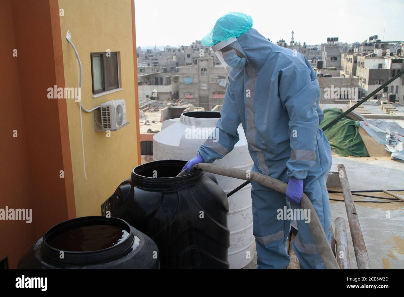30 août 2020 : Gaza, Palestine. 30 août 2020. Les équipes palestiniennes de défense civile livrent de l'eau potable aux foyers des résidents du camp de réfugiés de Jabalia infectés par le coronavirus, car ils restent en quarantaine et ne peuvent pas récupérer de l'eau potable. Depuis que les premiers cas de coronavirus ont été détectés dans la communauté de Gaza au début de la semaine dernière, le nombre de personnes infectées a régulièrement augmenté à plus de 180 dans l'enclave palestinienne assiégée et densément peuplée. La crise aigue de l'eau dans la bande, où plus de 95 pour cent de l'eau douce ne convient pas à la consommation humaine, met en évidence le déjà grave Banque D'Images