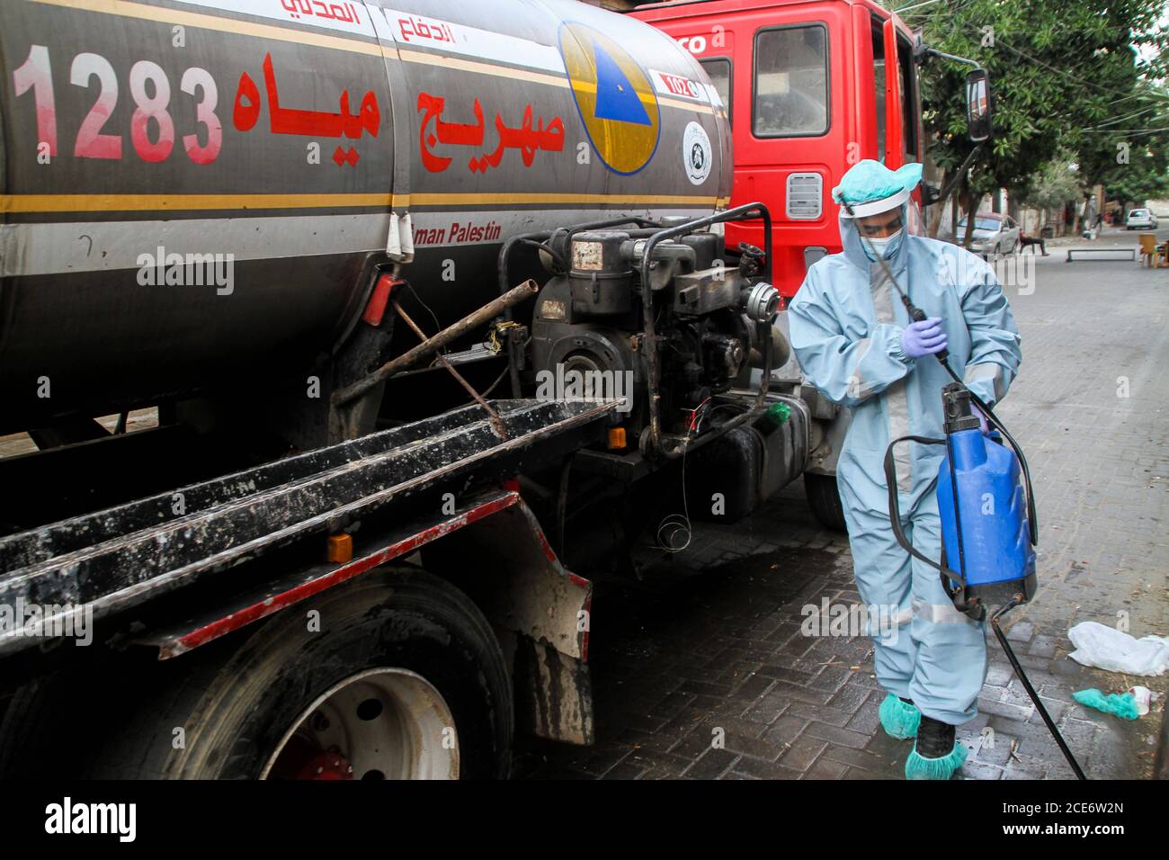 30 août 2020 : Gaza, Palestine. 30 août 2020. Les équipes palestiniennes de défense civile livrent de l'eau potable aux foyers des résidents du camp de réfugiés de Jabalia infectés par le coronavirus, car ils restent en quarantaine et ne peuvent pas récupérer de l'eau potable. Depuis que les premiers cas de coronavirus ont été détectés dans la communauté de Gaza au début de la semaine dernière, le nombre de personnes infectées a régulièrement augmenté à plus de 180 dans l'enclave palestinienne assiégée et densément peuplée. La crise aigue de l'eau dans la bande, où plus de 95 pour cent de l'eau douce ne convient pas à la consommation humaine, met en évidence le déjà grave Banque D'Images