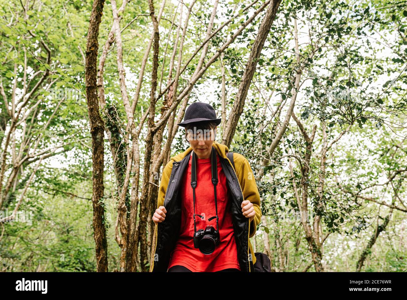 Tranquille jeune touriste femelle dans l'élégant port marchant dans le vert bois et profiter de la nature Banque D'Images