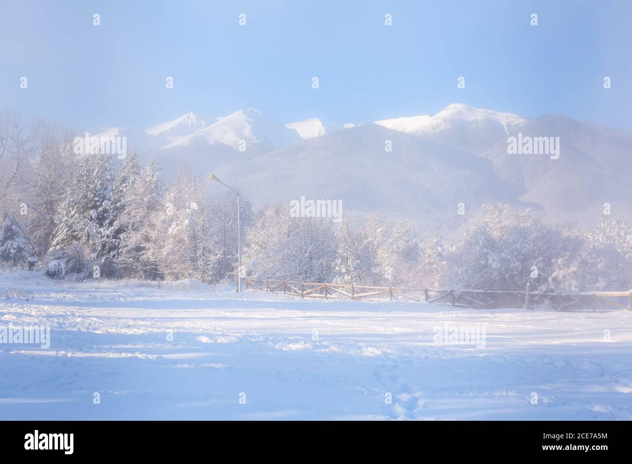 Forêt d'hiver, clôture en bois, pics de montagne Banque D'Images