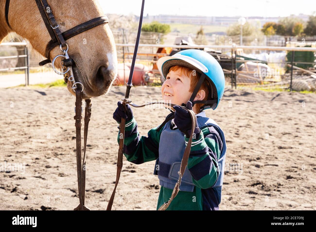 garçon dans le chapeau d'équitation et de bottes marchant le long de  paddock avec cheval dun pendant la leçon de dressage dans l'école équestre  Photo Stock - Alamy
