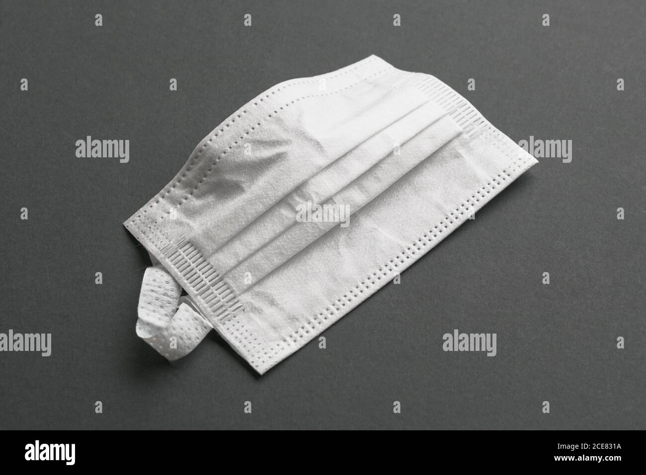 Masque médical de couleur blanche sur fond gris. Isolé. Banque D'Images