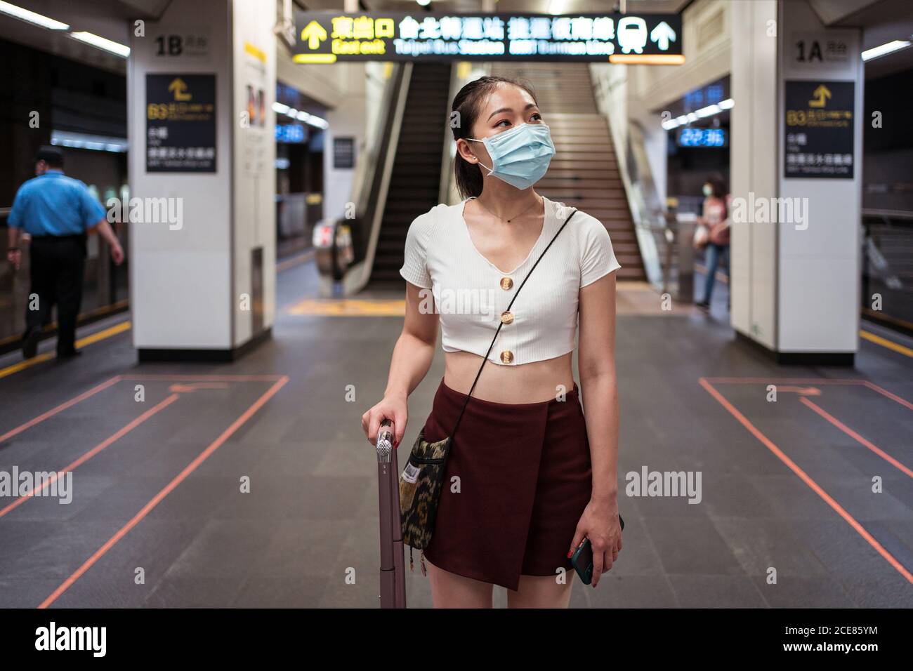 Pleine longueur jeune asiatique femme en mini jupe marche avec valise à la  gare en attendant le train Photo Stock - Alamy