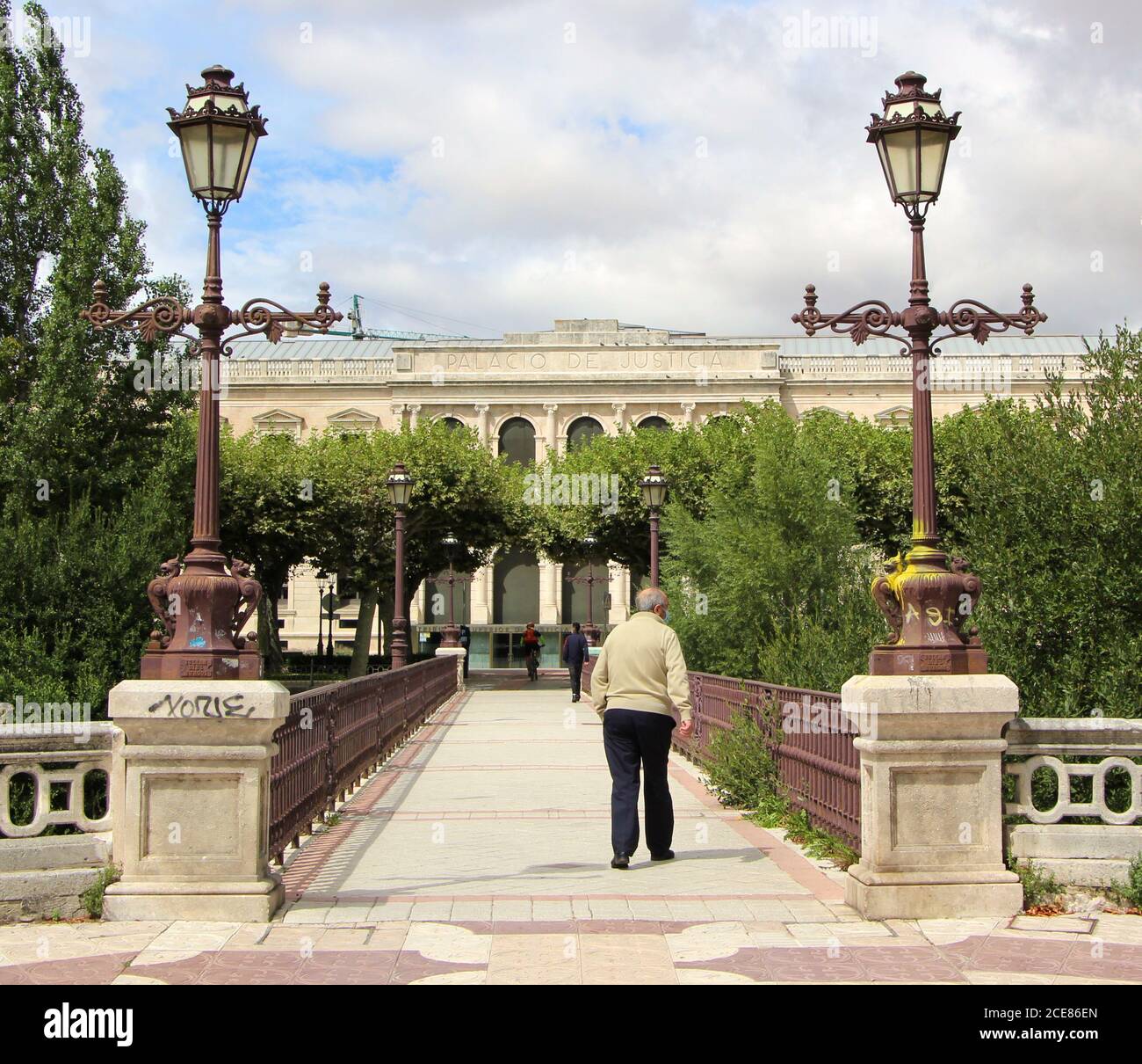 Le pont à pied et à vélo de Besson à Burgos en regardant vers Le palais de justice principal avec un homme senior qui traverse Castille Et Leon Espagne Banque D'Images