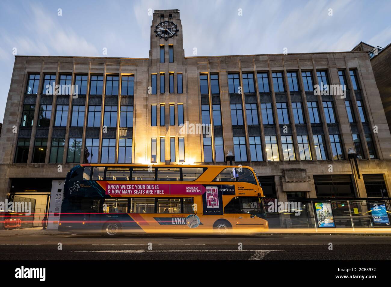 Un First bus à deux étages attend à un arrêt devant l'immeuble de bureaux art déco 33 Colston Avenue dans le centre-ville de Bristol. Banque D'Images