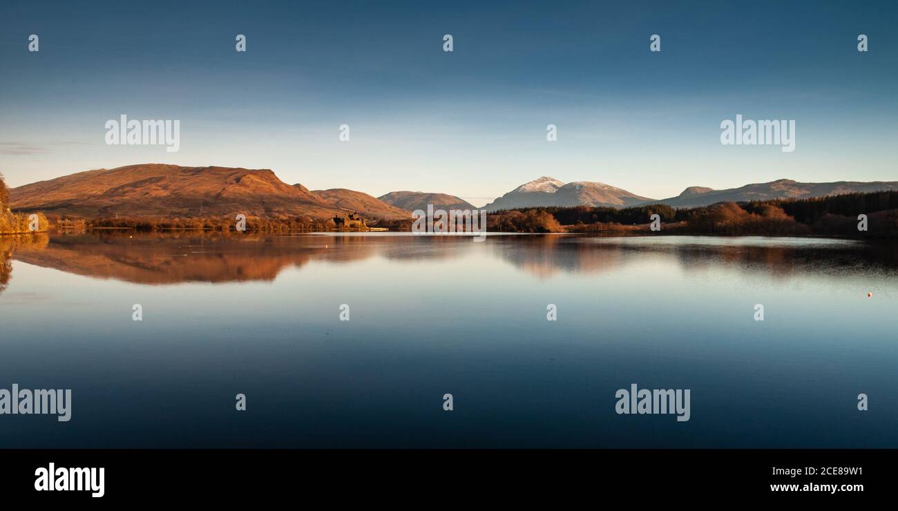 Le soleil d'hiver brille sur le château de Kilchurn, les vallées de Glen Orchy et de Glen Lochy, et la montagne de Ben Lui à côté du lac Loch Awe dans les West Highlands d'Écosse. Banque D'Images