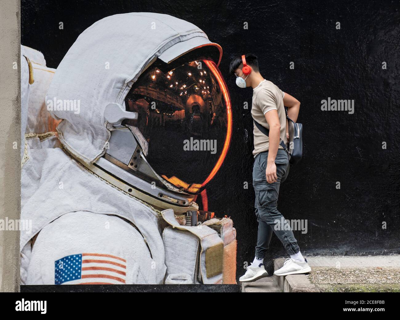 Hong Kong. 31 août 2020. HONG KONG, HONG KONG SAR : 31 AOÛT 2020. Un homme portant un masque passe devant l'image d'un astronaute portant son masque à Hong Kong. Bien que le port de masques à l'extérieur ait été un peu détendu, tout le monde dans la rue porte toujours un. L'art de rue annonce l'artiste français Vincent FournierÕs exposition, Space Project à la galerie la Galerie à Aberdeen Street Hong Kong. Alamy Live News/Jayne Russell Credit: Jayne Russell/Alamy Live News Banque D'Images