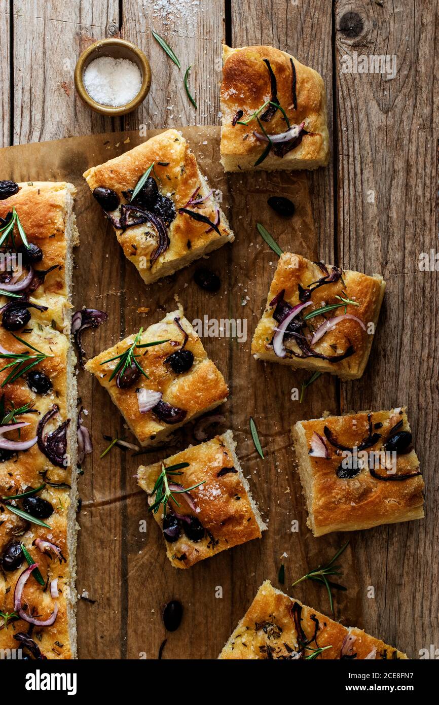 Focaccia aux olives noires et aux herbes sur une table en bois Banque D'Images