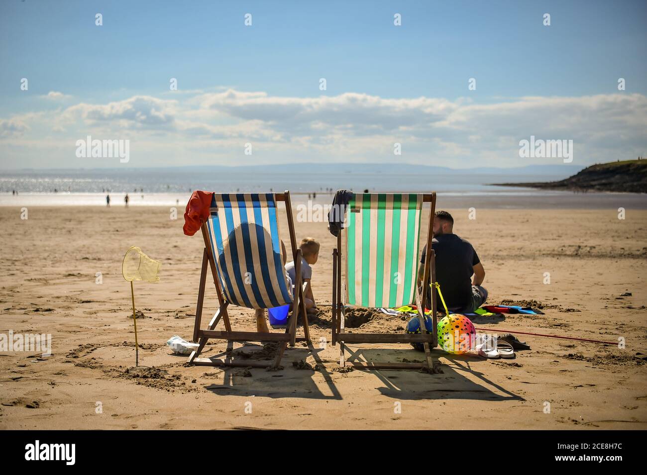 Chaises longues sur la plage de Barry Island, pays de Galles. Banque D'Images