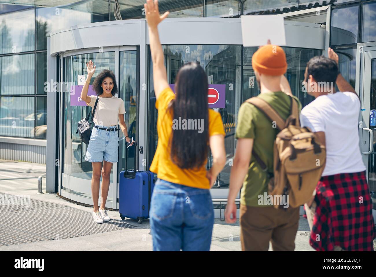 Des gens heureux et amicaux disent Au revoir à la charmante femme africaine à l'aéroport Banque D'Images