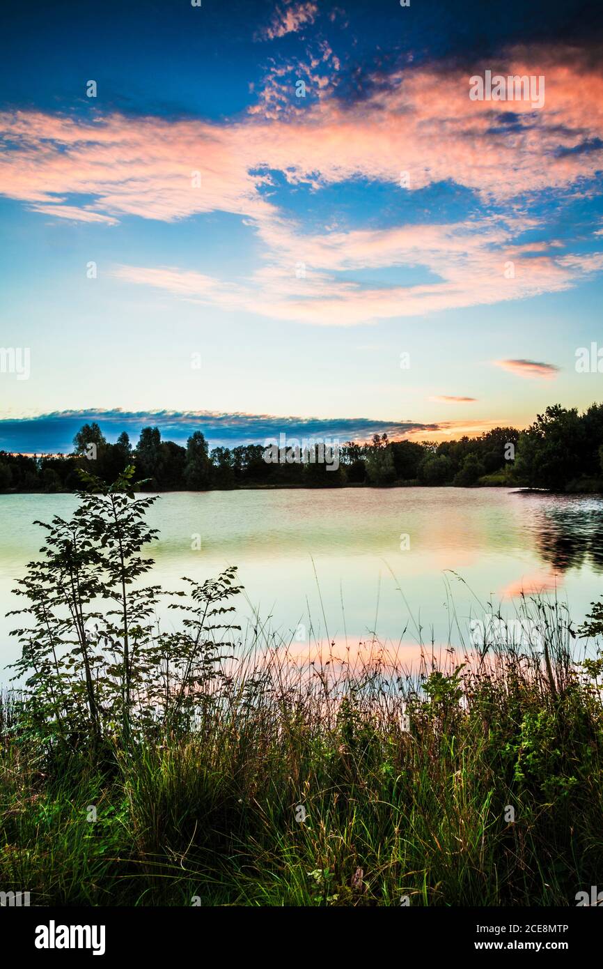 Lever du soleil en fin d'été sur l'un des lacs du parc aquatique de Cotswold. Banque D'Images