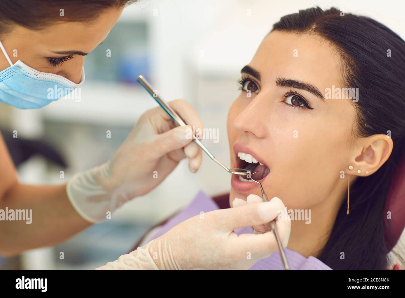 Dentiste examinant les femmes patients dent dans la clinique dentaire Banque D'Images