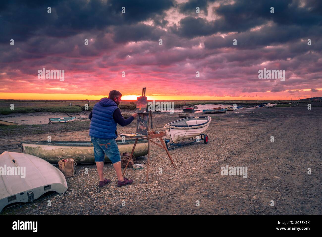 Un artiste peint le lever du soleil. Banque D'Images