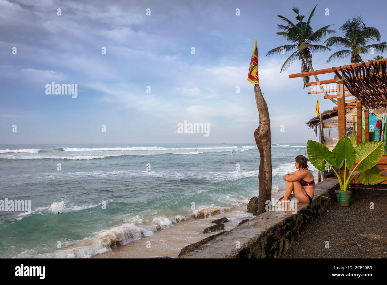 Sri Lanka, Ahangama, Surf Beach Hotel. Femme regardant la mer depuis le bar de la plage. Banque D'Images