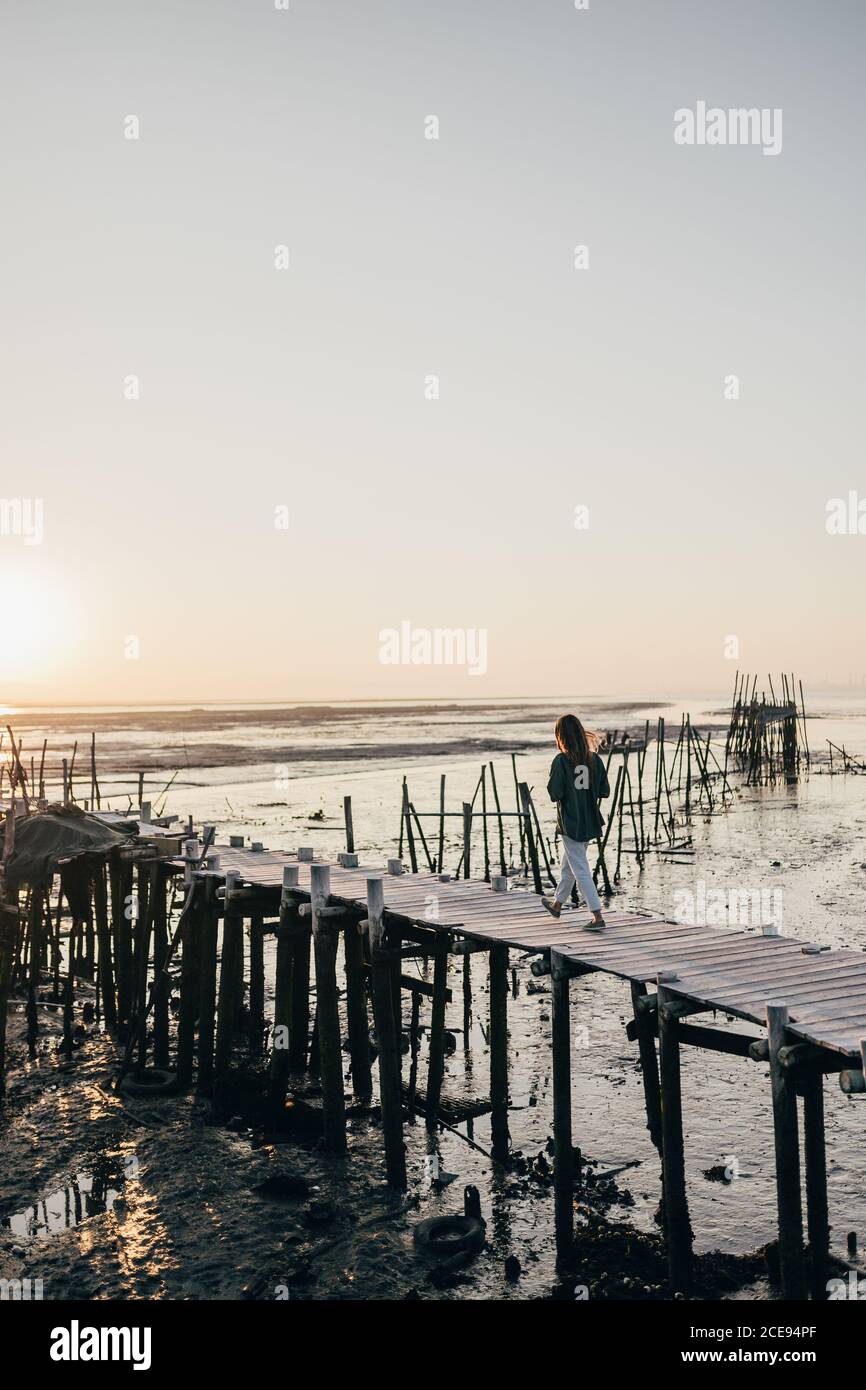 Femme sur une jetée en bois de merde dans l'océan Banque D'Images
