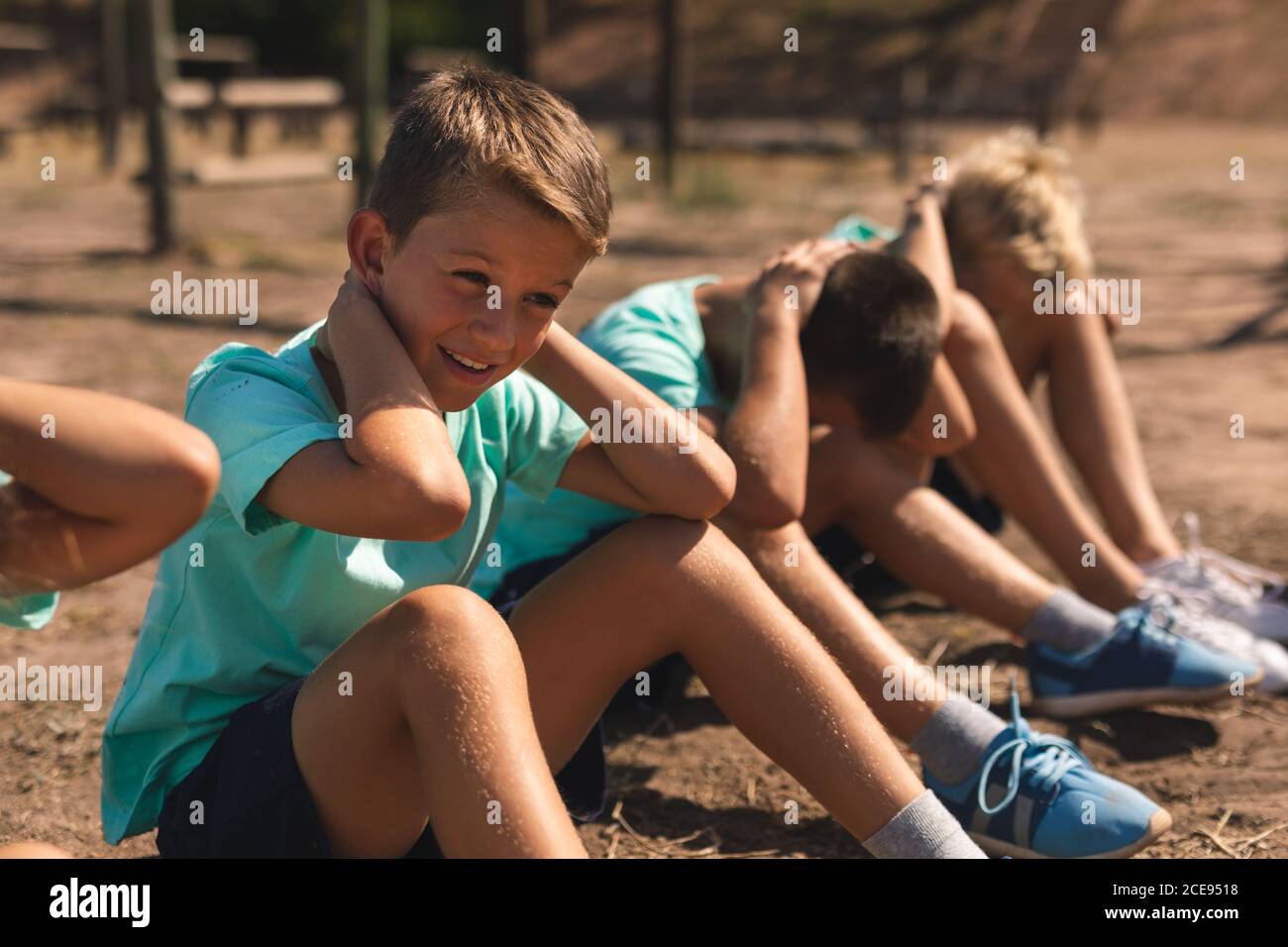 Groupe de garçons effectuant des sit-up à un camp d'entraînement Banque D'Images