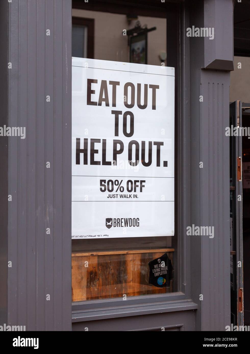 Inscrivez-vous sur une fenêtre du restaurant avec le message « Eat Out Pour aider » dans Carlisle Cumbria Royaume-Uni Banque D'Images