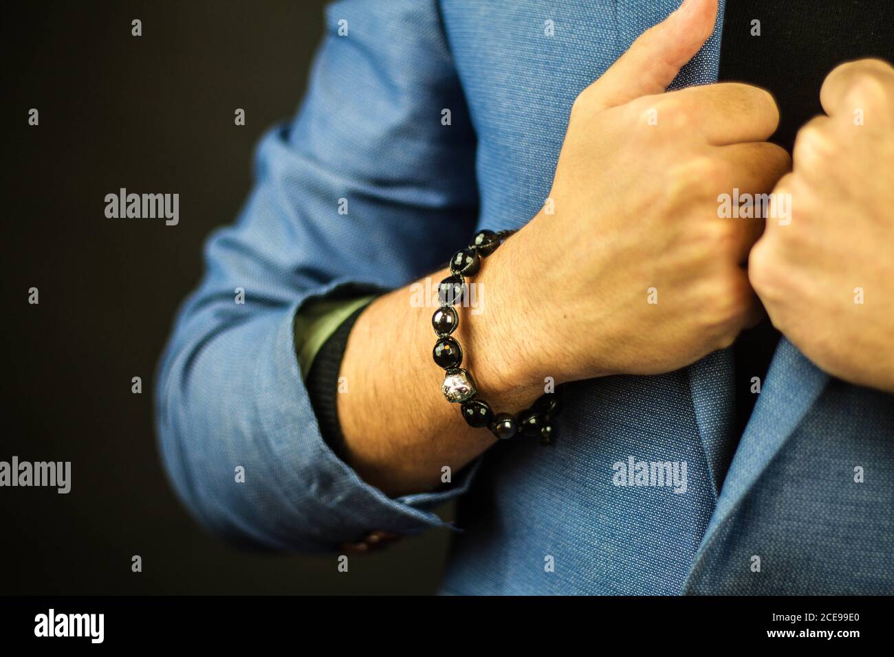 Gros plan d'un homme en costume portant un magnifique bracelet en pierres Banque D'Images
